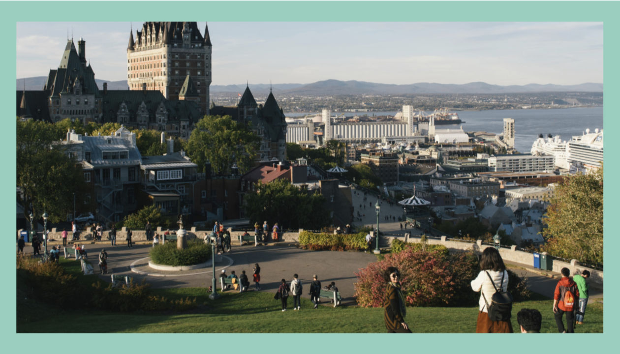 ケベックシティのエスプラネード パークからフェアモント ル シャトー フロントナック タワーを眺めながら、芝生でくつろぐ旅行者。 