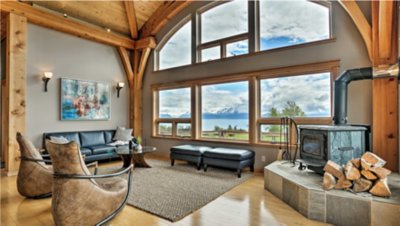 A rustic living room with a vaulted ceiling, large chandelier, and comfortable seating.