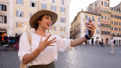 A woman in Rome wearing a hat and talking to her phone.