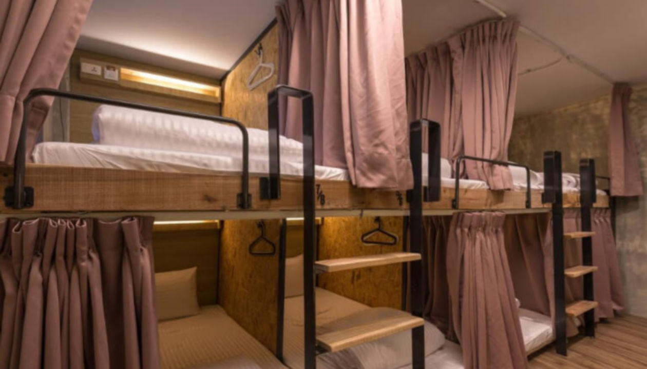 Ein Zimmer ähnlich einem Schlafsaal mit Etagenbetten und Vorhängen