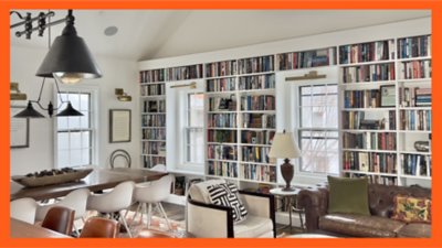 Spacious library lounge with large bookshelves, cozy seating, and natural light