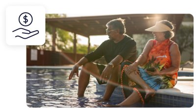 An elderly couple sitting at the edge of a pool with their feet soaking in the water