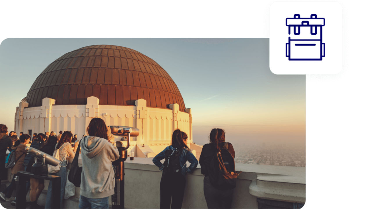 A group of people looking through telescopes at an observatory