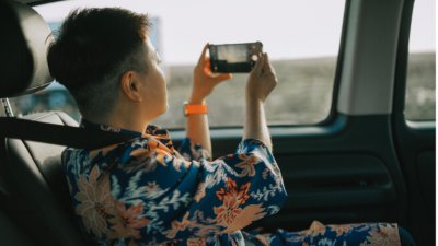 A person recording a video from a moving car.