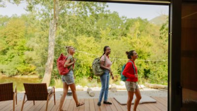 Photo of young African American woman and her friends arriving at vacation rental home for the weekend.