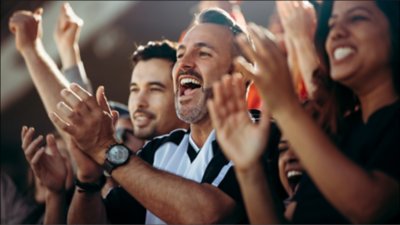 Group of enthusiastic fans cheering and clapping in a stadium, celebrating during a sporting event