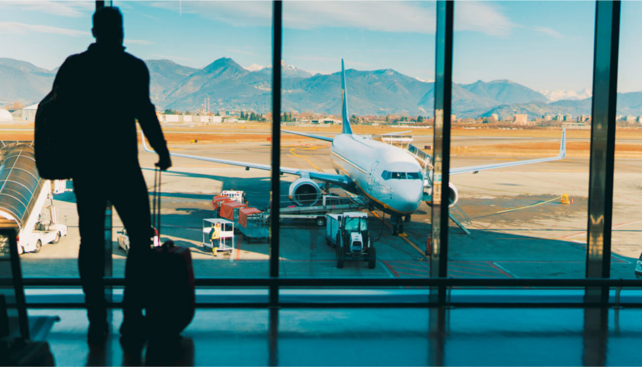 A man looking at an airplane sitting on the tarmac.