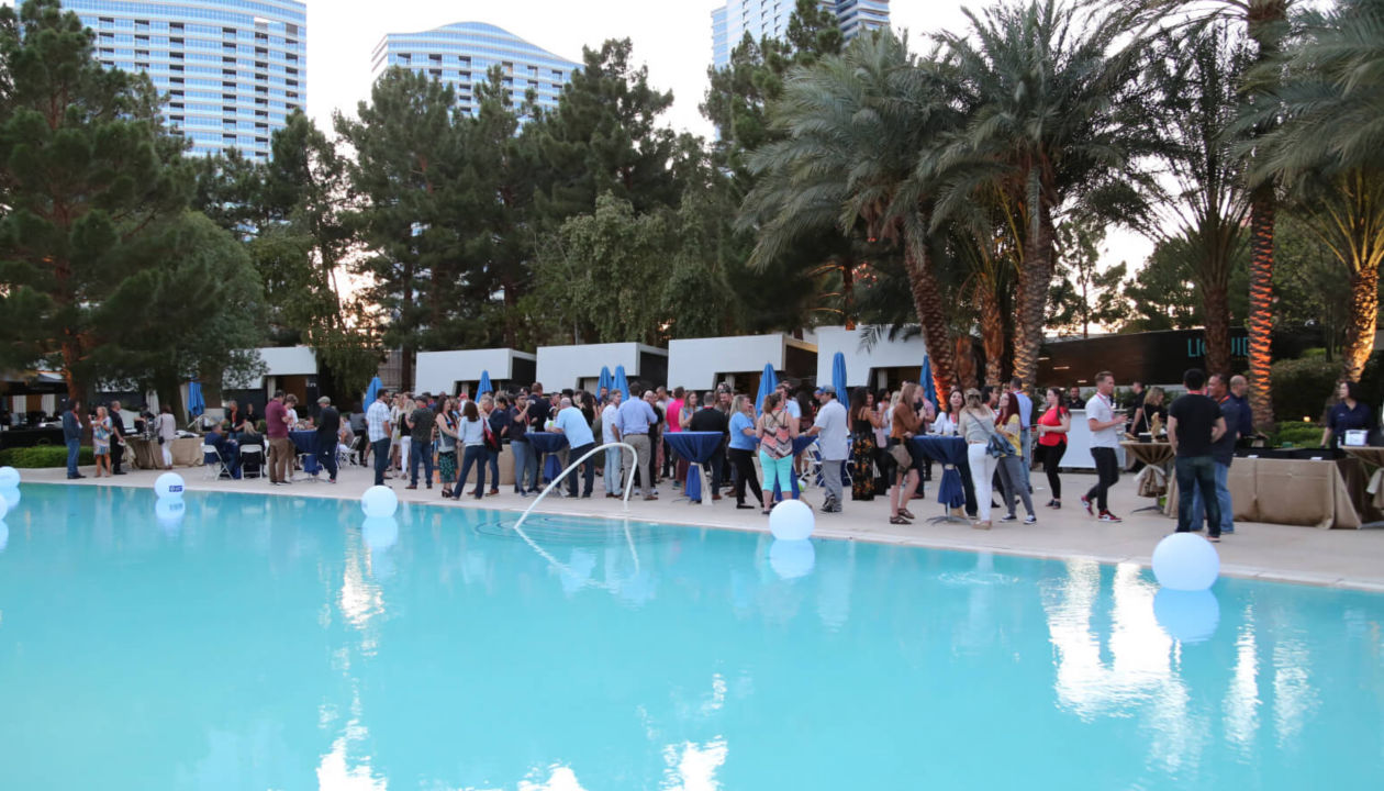 Des participants à l’événement Explore 2022 échangent près d’une piscine.