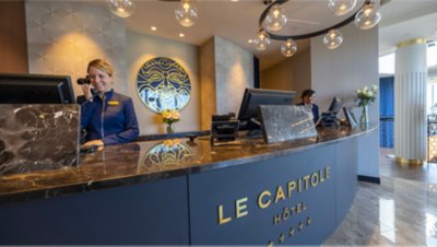 Le Capitole Hôtel’s lobby with employees behind the reception.