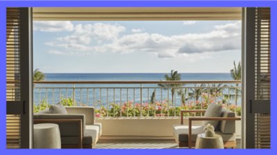 Luxury hotel terrace with two chairs and flower garden overlooking the ocean and palm trees