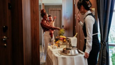 Expedia guests welcome hotel staff at their door while they are delivered room service as part of one of the in room amenities.