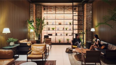 A view of the modern lobby of the Hotel Ananti at Gangnam in Seoul South Korea, with two people in conversation in a seating area.