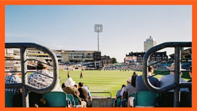 Spectators watching a daytime sports match in a city stadium from behind the stands