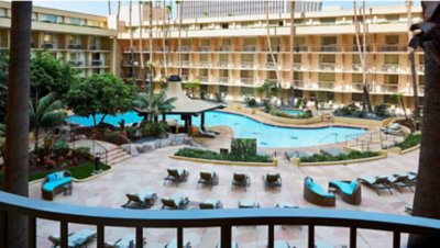 Image of a Marriott Hotel atrium and outdoor swimming pool with lounge chair seating