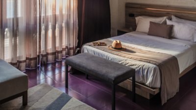 A warm, inviting hotel room with a neatly made bed and soft lighting.