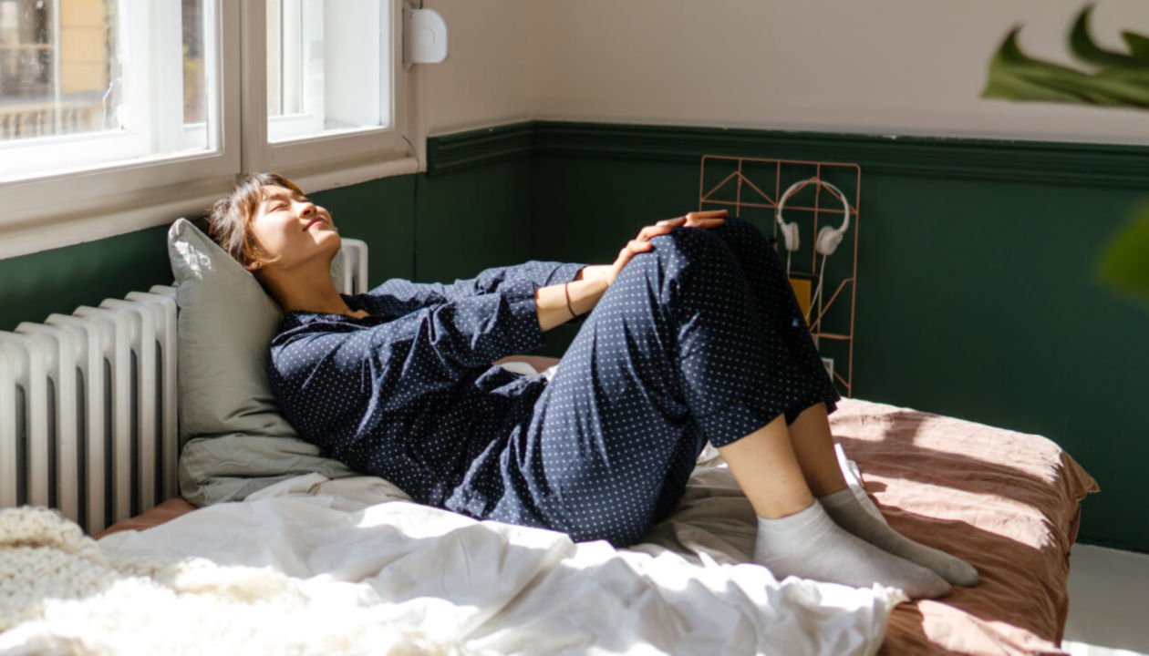 Eine Frau im Urlaub entspannt sich auf einem Bett