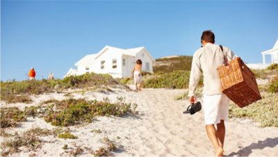 Foto de pai e filho voltando para uma casa de praia alugada